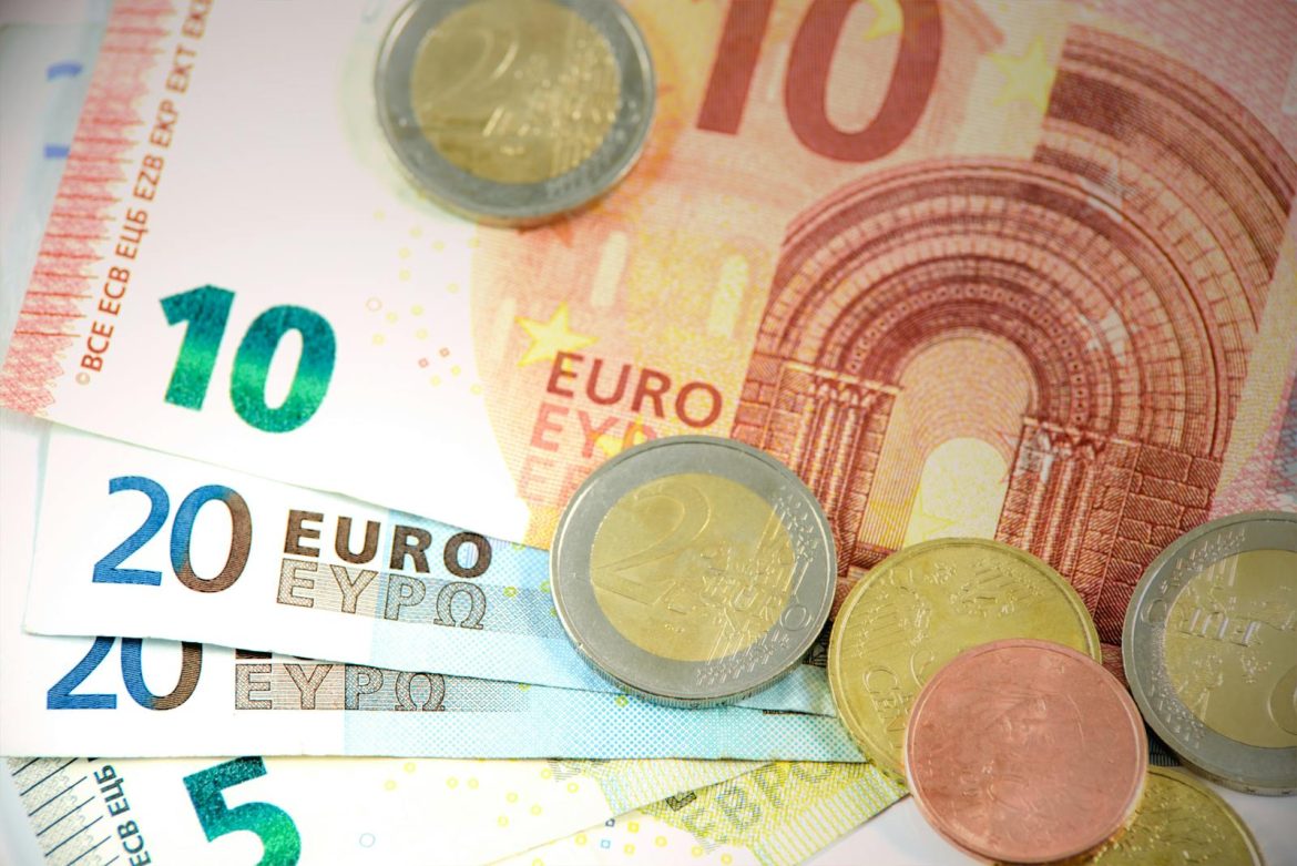 Detailed shot of Euro banknotes and coins showcasing currency denominations.