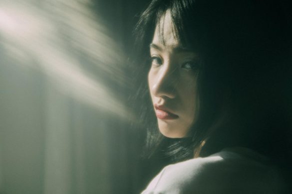 Portrait of a thoughtful young woman in soft sunlight, creating a dreamy and contemplative mood.