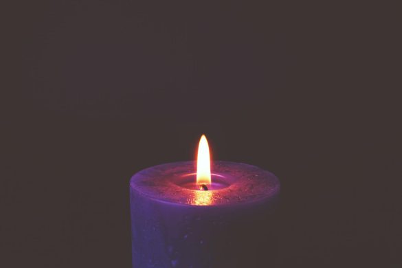 A soothing candle flame glowing in darkness, creating a peaceful mood.