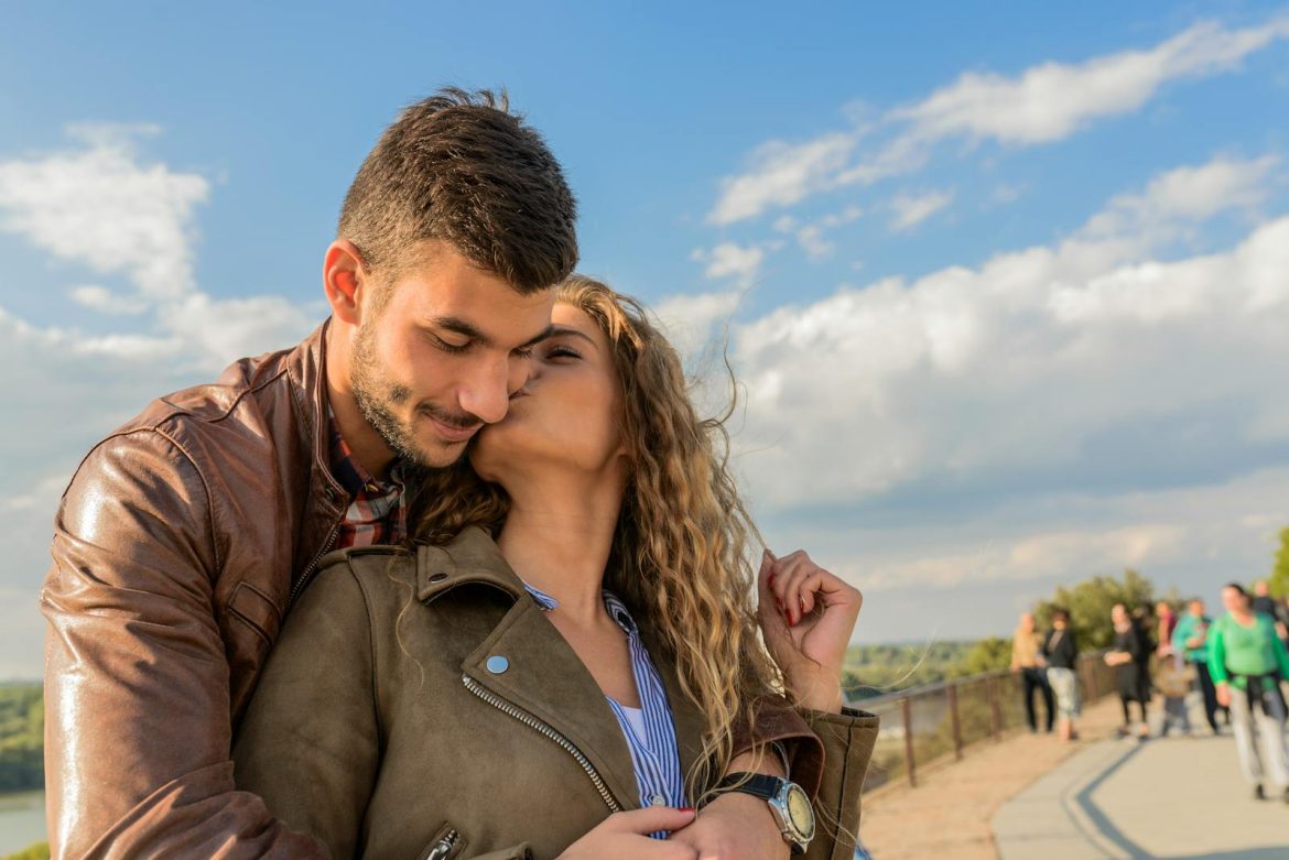 A loving couple embraces under a clear sky, showcasing romance and togetherness.
