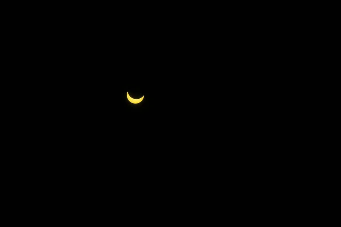Minimalist image of a crescent moon glowing in a dark night sky.