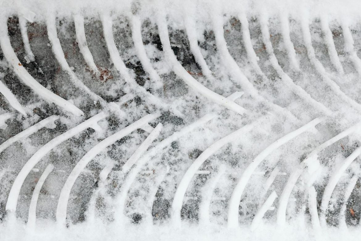 Close-up of a tire track in fresh snow showcasing a unique pattern and texture.