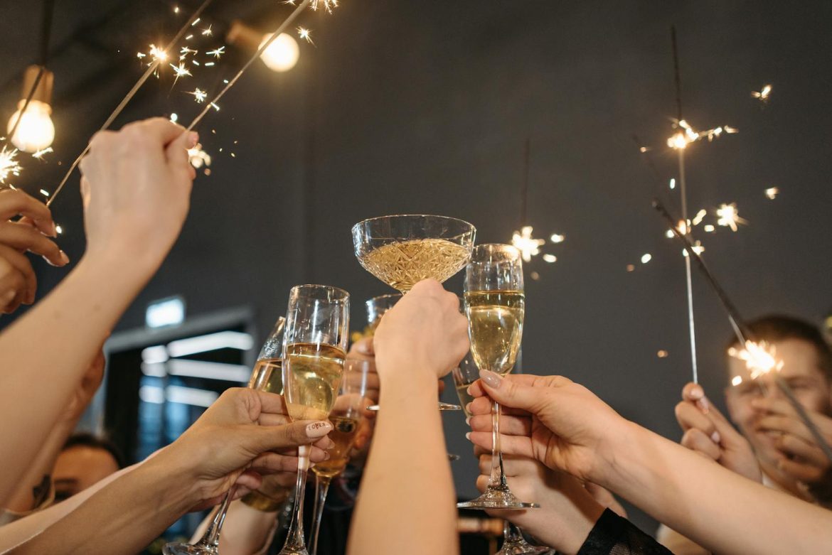 A group of adults celebrating with champagne and sparklers indoors. Perfect for festive occasions.