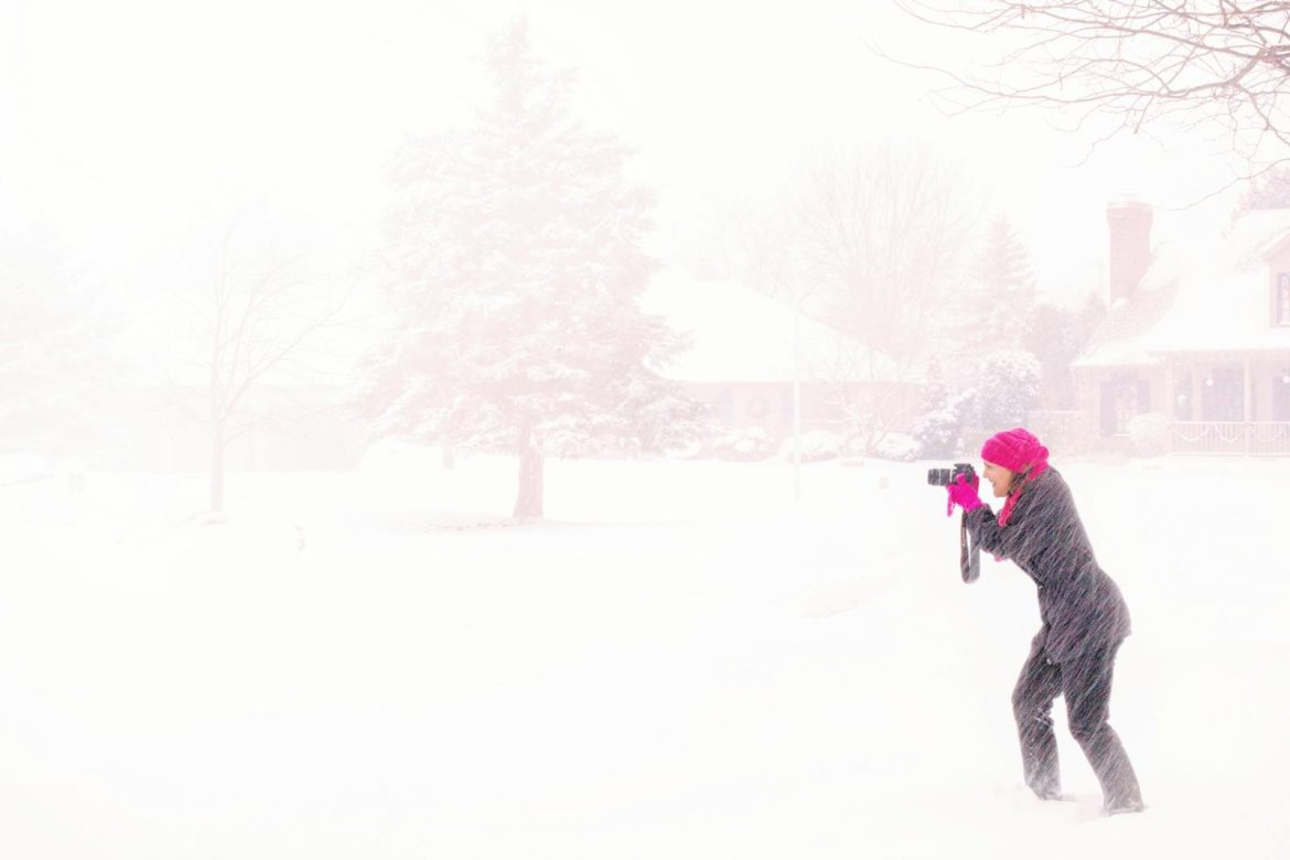 A dedicated photographer braves the blizzard, capturing the beauty of a winter snowstorm.