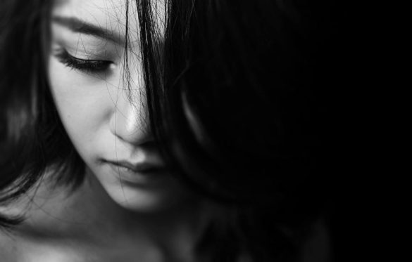 Monochrome close-up of a young woman with a thoughtful expression, emphasizing emotions.