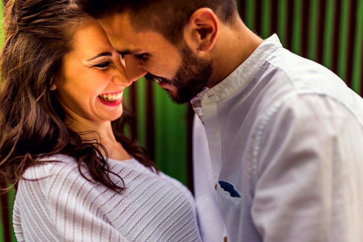 Close-up of a happy couple laughing and embracing outdoors in Toledo, Spain.
