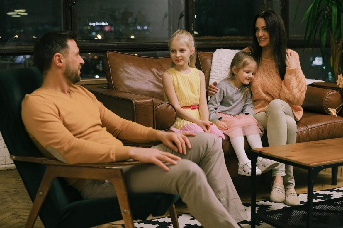 A family of four enjoying quality time together in a cozy indoor setting.