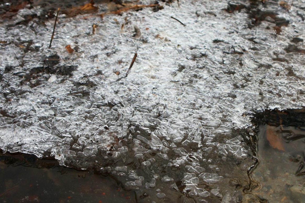 Close-up of icy textures on a frozen river in Chiavenna. Captures winter's intricate beauty.