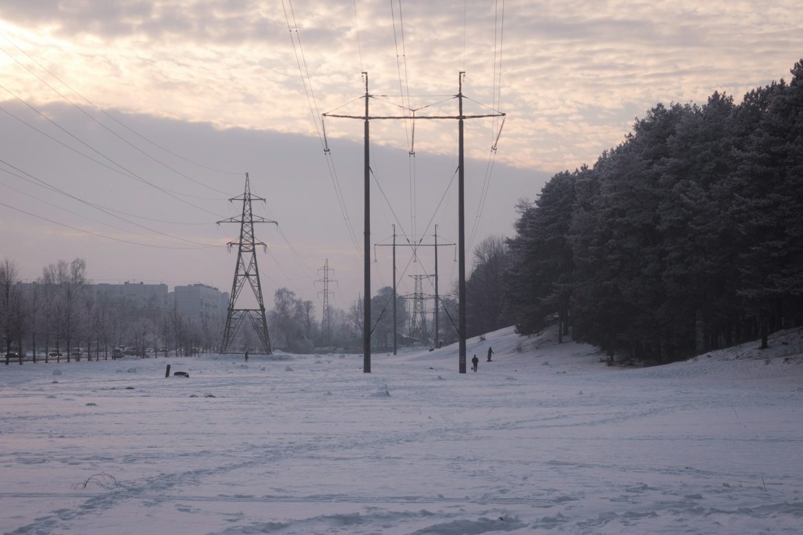 Power lines stretch across a snowy, winter landscape.