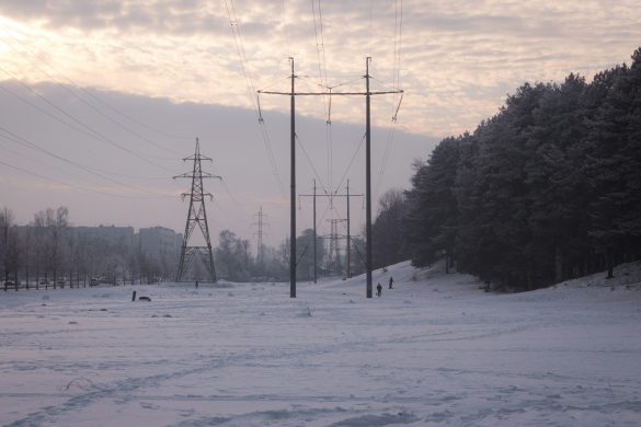 Power lines stretch across a snowy, winter landscape.