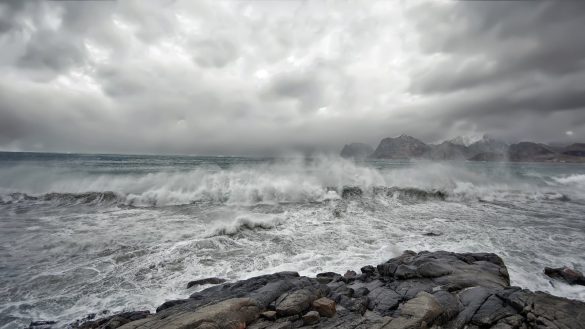 Moody seascape capturing a stormy coastline in Lofoten, Norway with crashing waves.